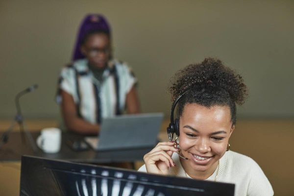 Customer service agent taking calls in office providing modern CX to clients