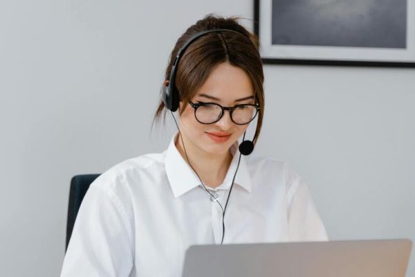 Woman wearing a headset providing support through a customer experience management system