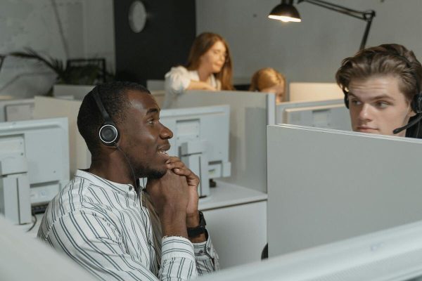 Customer service agents collaborating in an office to deliver customer support across multiple channels