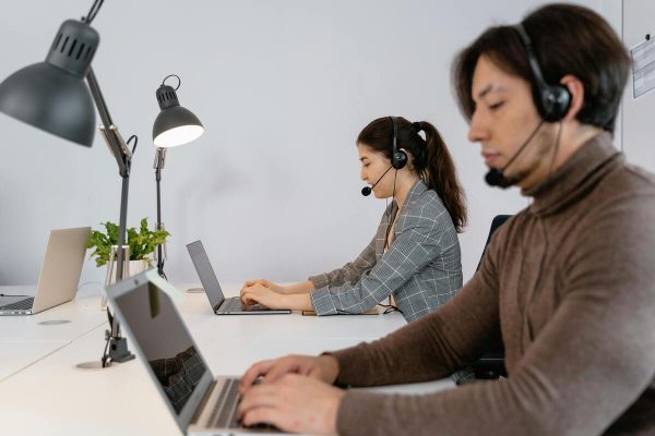 Customer support agents handling calls in an outsourced outbound call center services setup