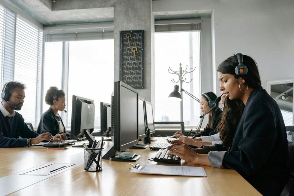 Office team wearing headsets while working at computers.