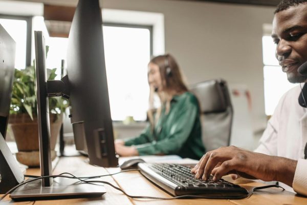 Customer service agents taking calls in a support center, illustrating call center outsourcing pricing