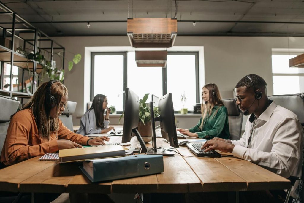 Customer service outsourcing agents handling calls at desks