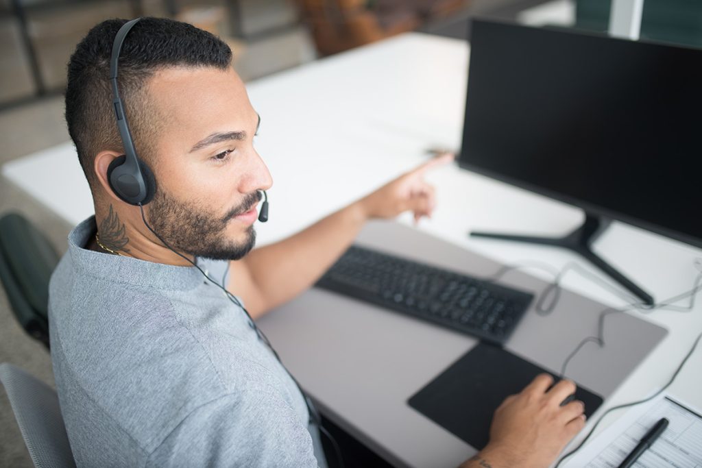 Customer support staffing agency agent assisting callers by phone and desktop