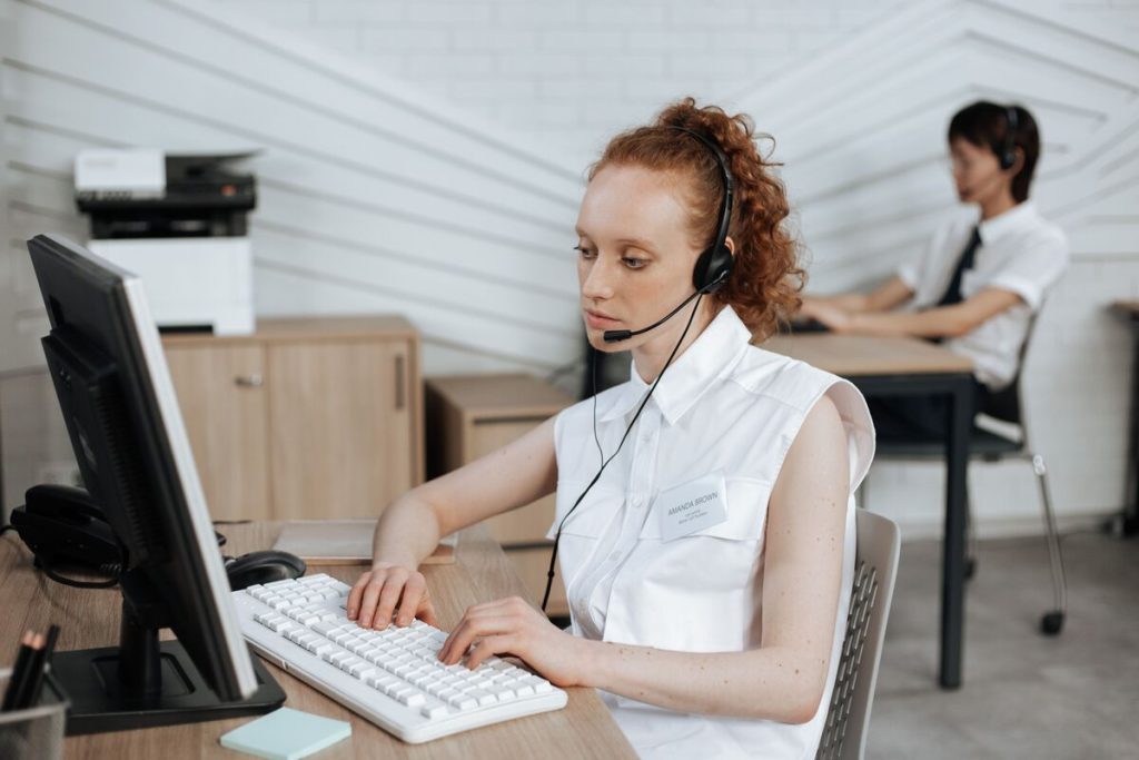 Call center outsourcing agent wearing a headset assisting customers through professional customer support in a modern contact center.