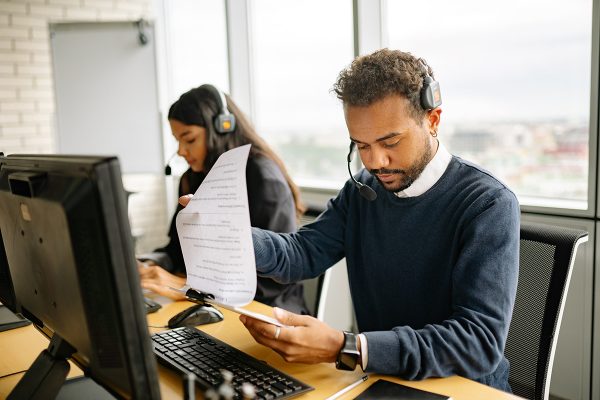Customer support documentation representative reviewing printed records