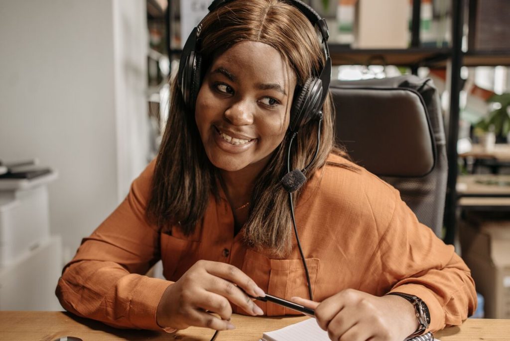 Smiling call center agent wearing a headset providing excellent customer support and ensuring customer satisfaction.