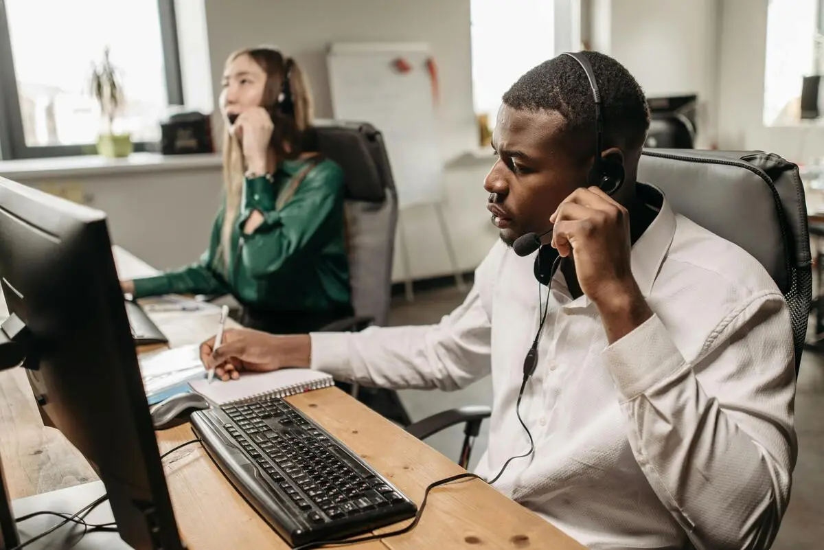 Team of customer service agents taking calls, following customer support best practices in the office.